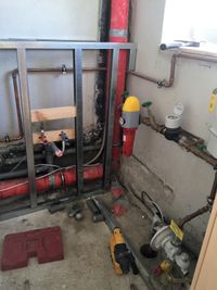 Baustelle im Technikraum mit Rohren und Handwerkzeug