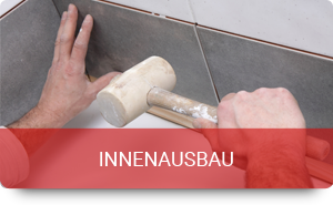 Handwerker verlegt Fliese mit Gummihammer